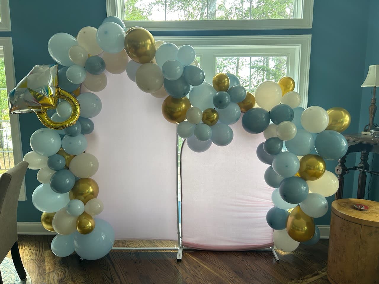 Sage, dusty blue, and gold balloon arch with a ring balloon accent
